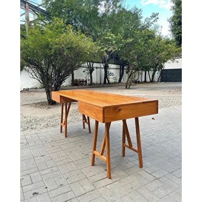 two wooden tables sitting next to each other on top of a brick floored area