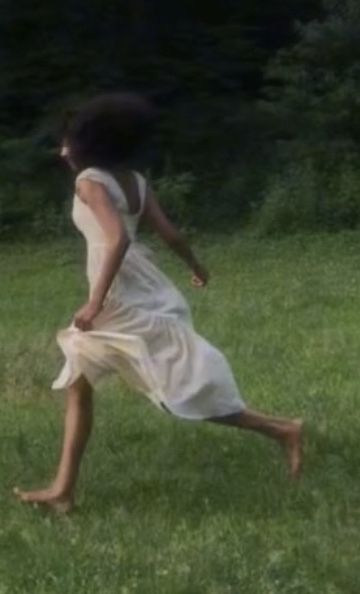 a woman in a white dress is running through the grass