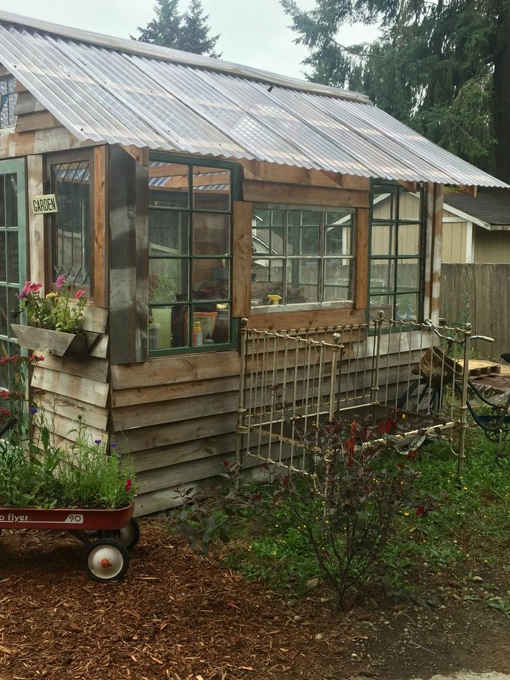 a small wooden house sitting in the middle of a yard