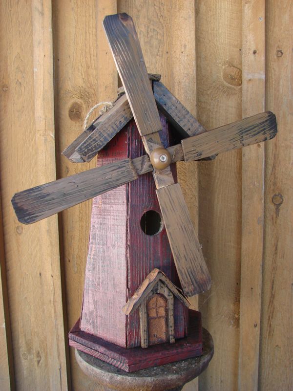 a birdhouse made out of wooden boards with a windmill on the top and roof