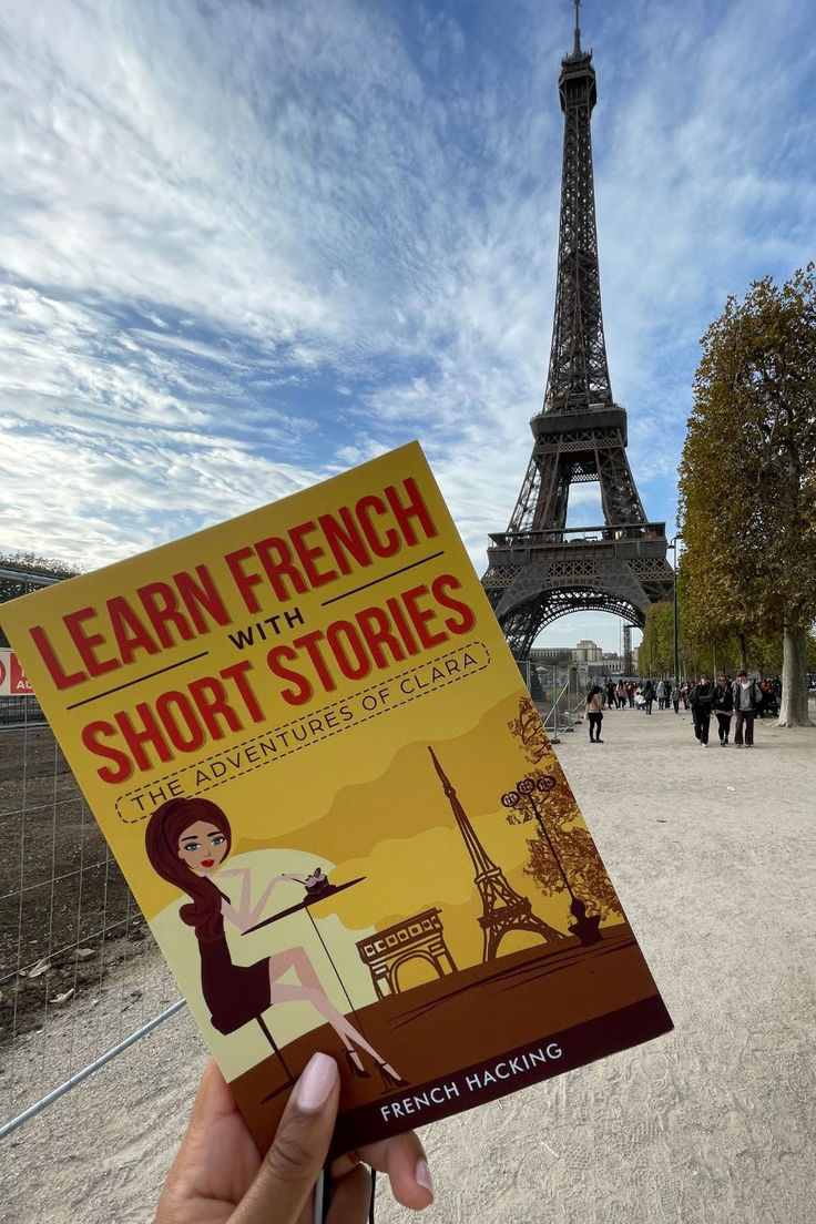 a person holding up a book in front of the eiffel tower with short stories written on it