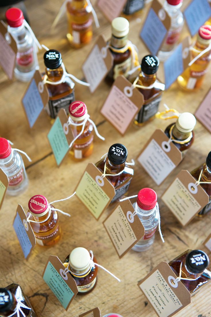 many small bottles with labels on them sitting on a table