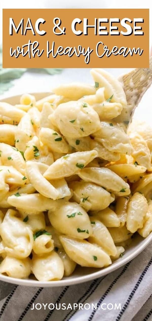 macaroni and cheese with heavy cream in a white bowl on a striped cloth