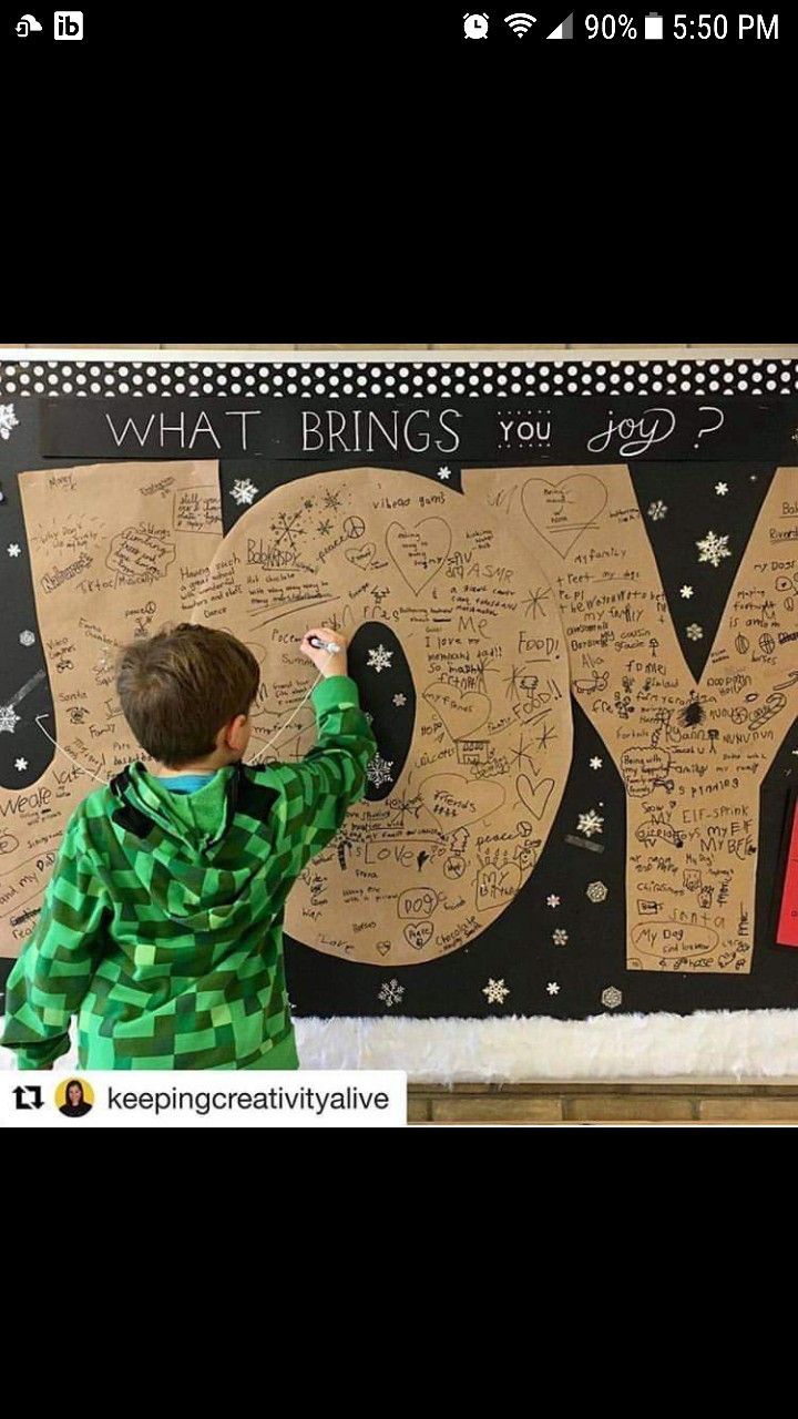 a young boy writing on a bulletin board with the words do what brings you joy