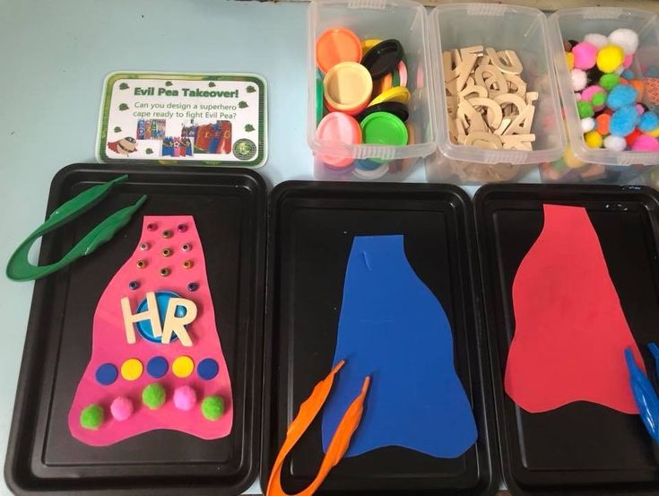 three plastic trays filled with crafting supplies on top of a table next to each other