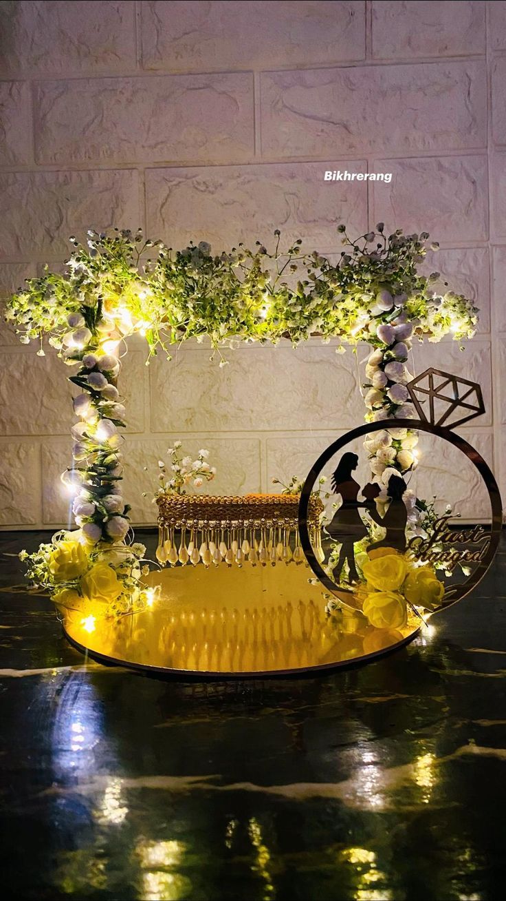 a yellow comb is sitting on a table with flowers and greenery around it in front of a white brick wall