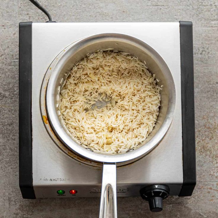 a pan filled with rice sitting on top of a stove