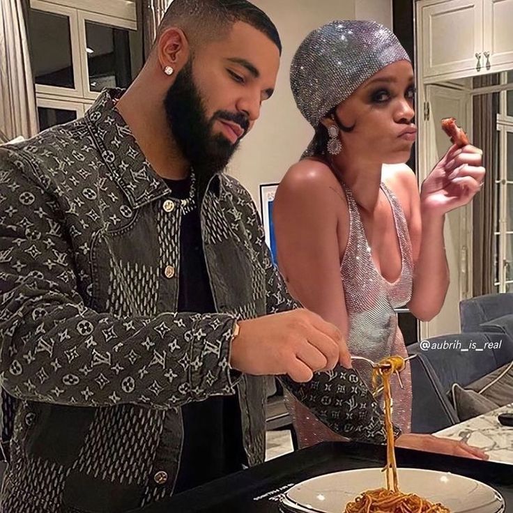 a man and woman standing over a plate of spaghetti with sauce on it while one holds a fork in the other hand