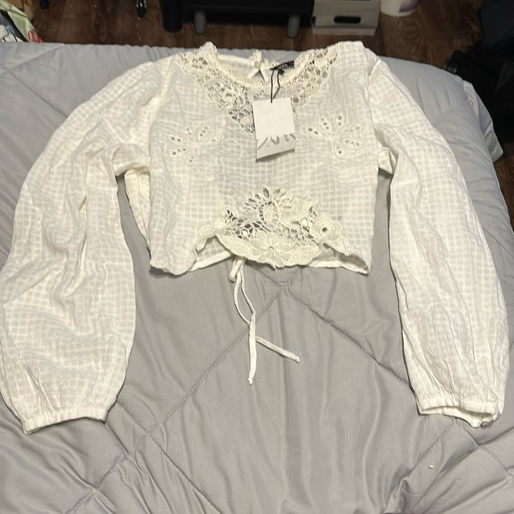 Brand New With Tags! Beautiful Blouse With Embroidery Detailing In The Front And Lovely Open Back That Ties At Waist. Has The Smallest Tear On Upper Back Right Shoulder. Fabric Is Very Delicate Summer Long Sleeve Embroidered Lace Top, Long Sleeve Embroidered Lace Top For Summer, Spring Embroidered Cotton Lace Top, Summer Floral Embroidered Long Sleeve Lace Top, Summer Long Sleeve Lace Top With Floral Embroidery, Summer Embroidered Long Sleeve Top With Lace Trim, Summer Long Sleeve Embroidered Top With Lace Trim, Spring Long Sleeve Lace Tops, Spring White Lace Top With Lace Work