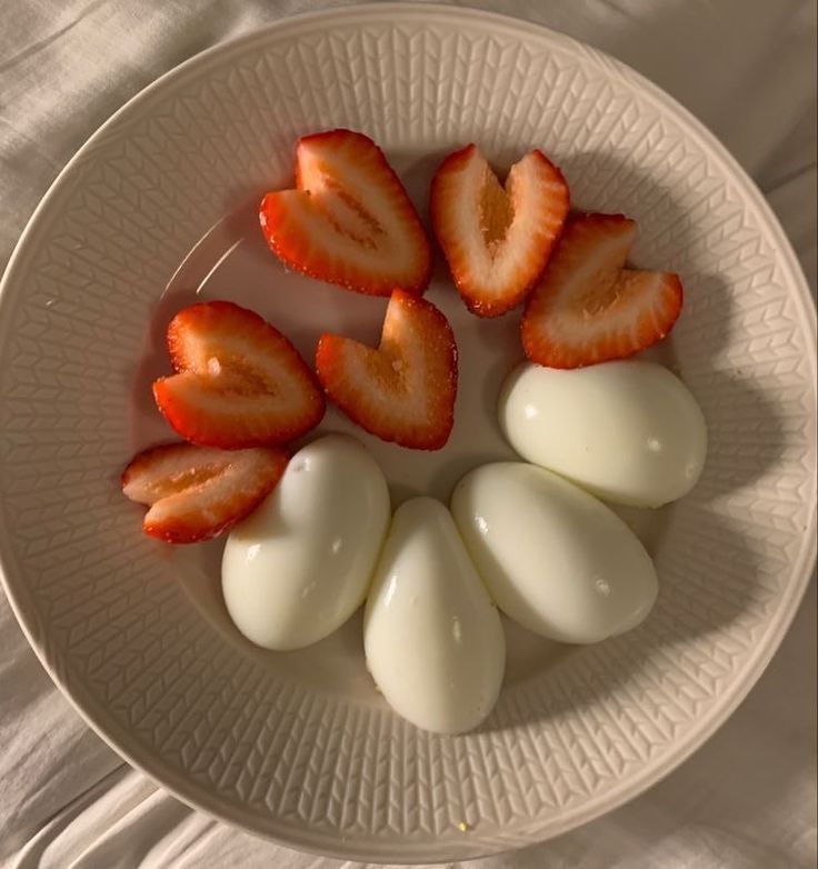 sliced strawberries and eggs on a white plate