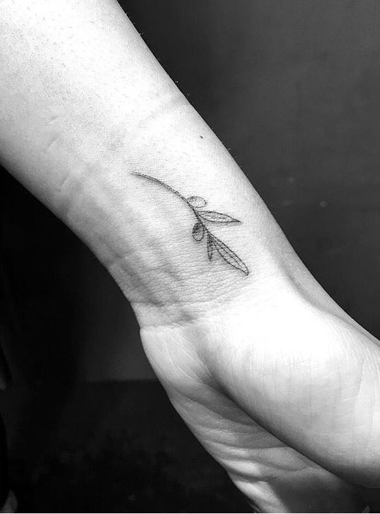 a black and white photo of a person's foot with a small tattoo on it