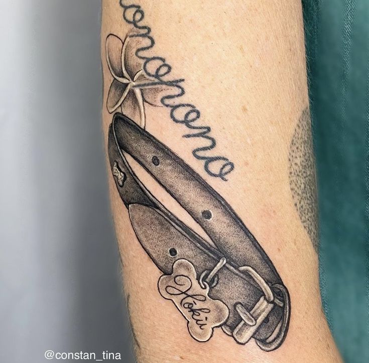 a black and white photo of a tattoo with a knife on it's arm