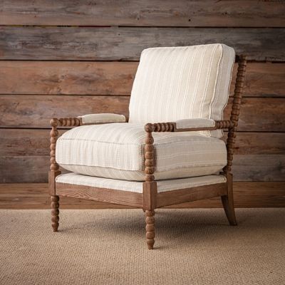 a white chair sitting on top of a rug in front of a wooden paneled wall