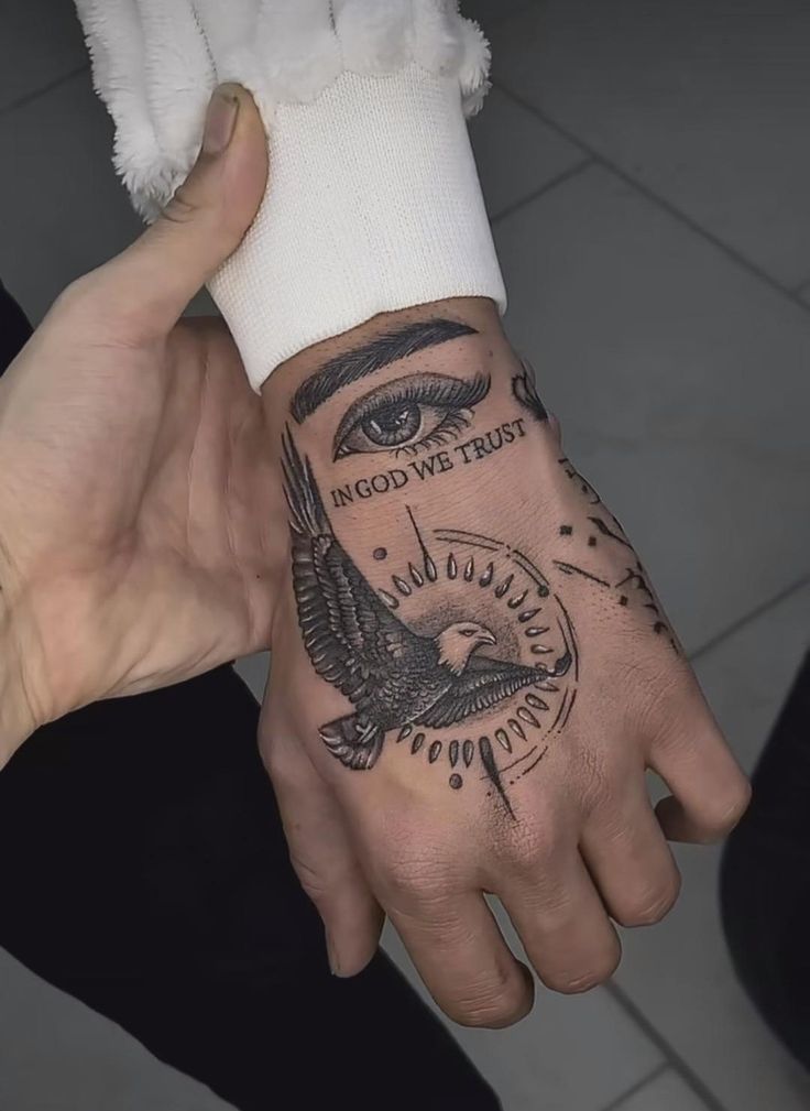 a person's hand with a tattoo on it and an eye in the middle