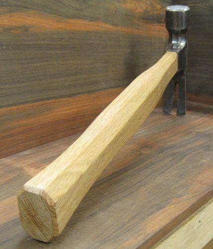 a piece of wood that is on top of a wooden table next to a hammer