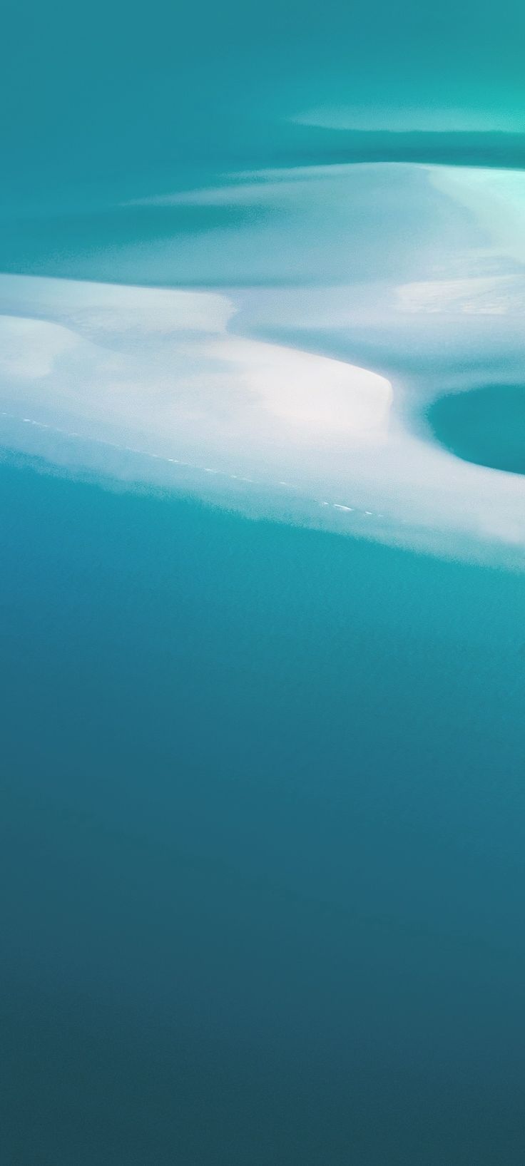 an airplane flying over the ocean with white clouds in the sky and blue water below