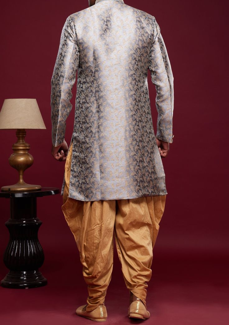 Ready-Made Sherwani With Peshawari Trouser. All Over Jacquard Brocade Style Fabric Top. Art Silk Peshawari Ready Made Trouser. Crafted in Chinese Collar Neck, and Full Sleeve. Satin Lining with Plain Work. High-Quality Matching Buttons. Please Note: The footwear shown in the picture is for presentation and photography purpose only. Color: There might be slight color variation due to lightings and flashes while photo shooting. The color may also vary because of different screen resolutions. Wash Fitted Salwar Kameez For Traditional Ceremonies With Dabka, Fitted Kurta With Dupatta For Traditional Ceremonies, Traditional Bandhgala With Zari Weaving For Festive Season, Traditional Bandhgala With Zari Weaving, Festive Traditional Bandhgala With Zari Weaving, Festive Bandhgala With Zari Weaving, Festive Brocade Salwar Kameez With Dabka, Unstitched Brocade Salwar Kameez For Festivals, Long Sleeve Jamawar Salwar Kameez For Traditional Ceremonies