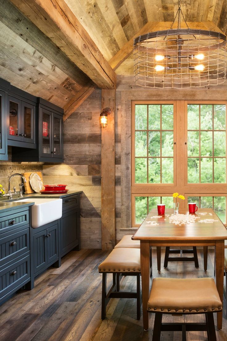 a kitchen with wooden walls and flooring next to a window filled with light bulbs