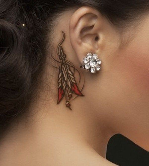 a woman's ear is decorated with flowers and leaves, while the other side has a feather on it