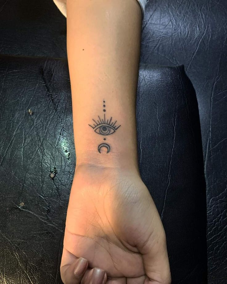 a woman's arm with an all seeing eye tattoo on the left side of her wrist