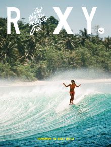 a man riding a wave on top of a surfboard in front of palm trees