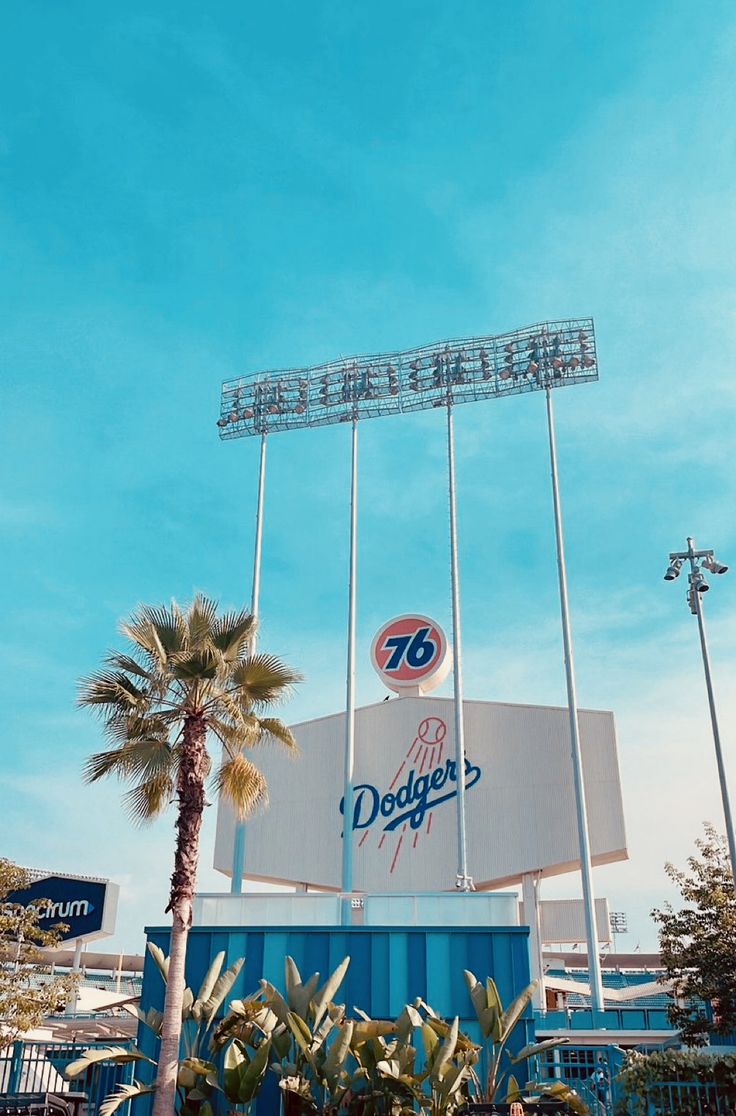 the dodgers stadium sign and palm trees are in front of it