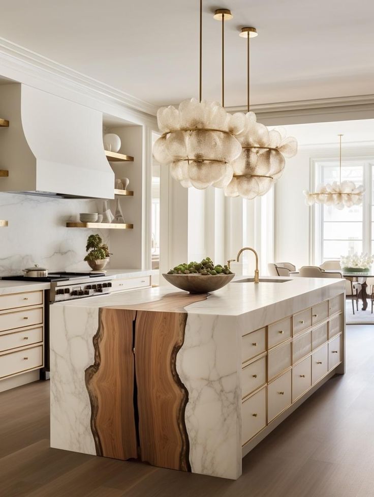 a large kitchen island with marble counter tops and wooden cabinets in the center, surrounded by hanging lights