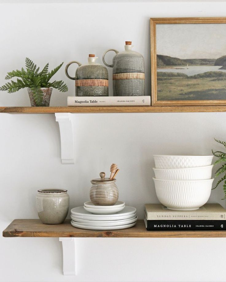 two shelves with plates, cups and vases on them