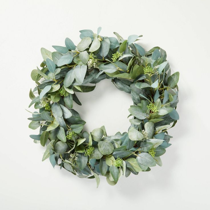 a wreath made out of green leaves and greenery