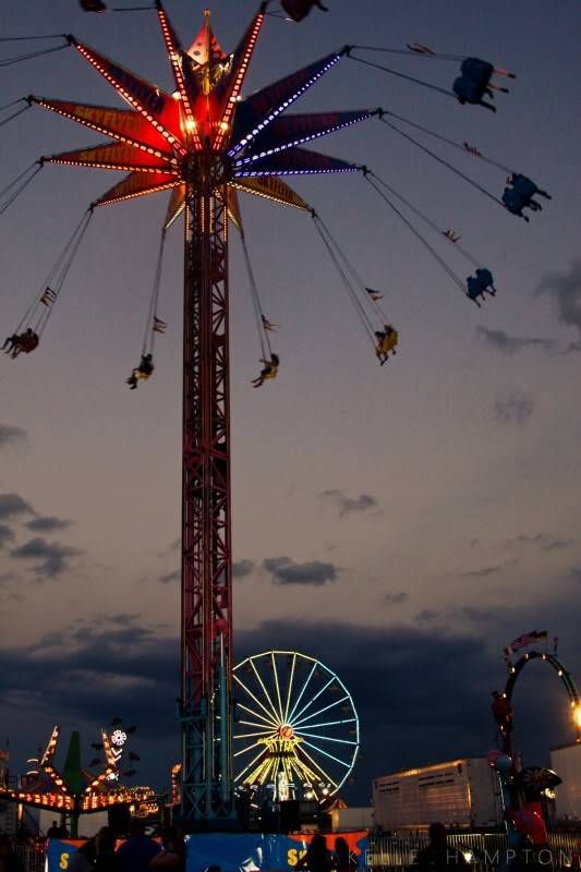 an amusement park at night with people on the rides