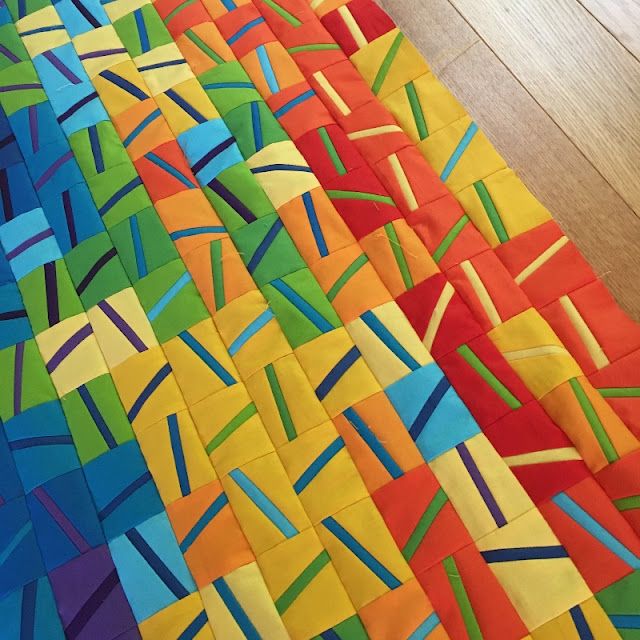 a colorful quilt is laying on the floor