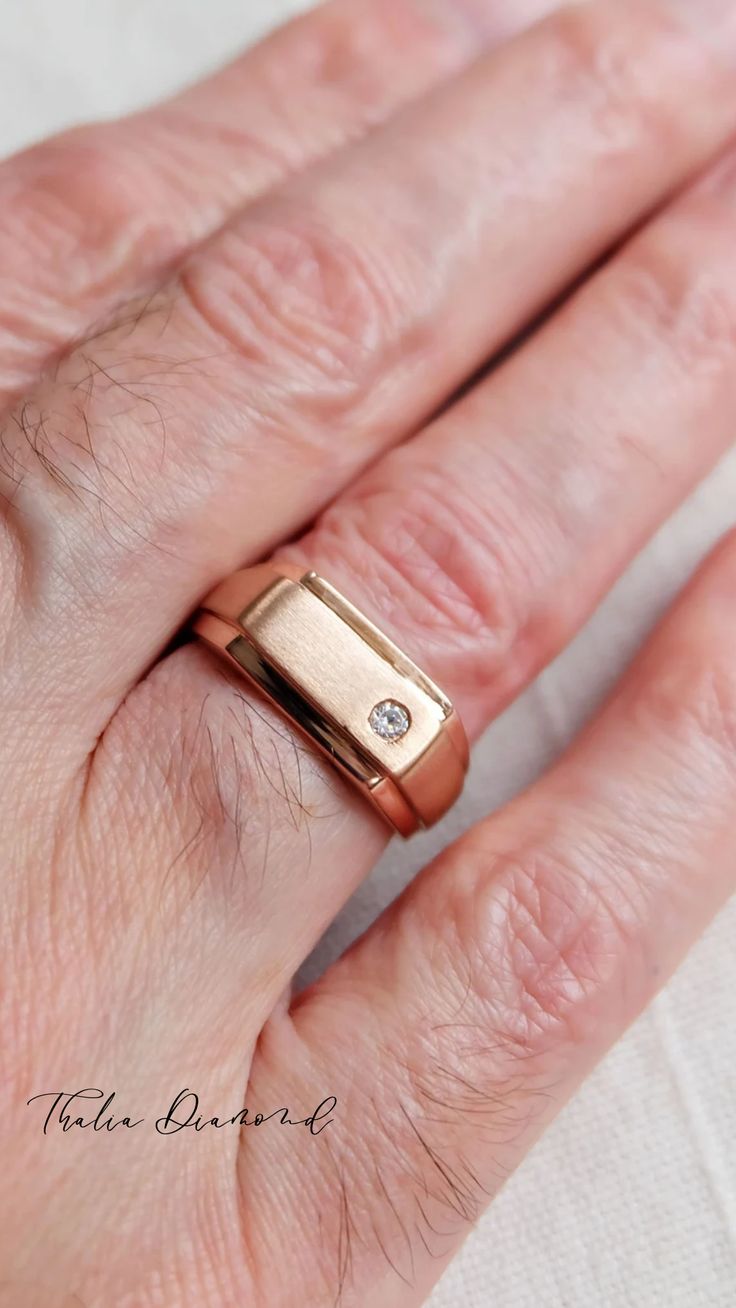 a woman's hand with a gold ring on top of it and a diamond in the middle