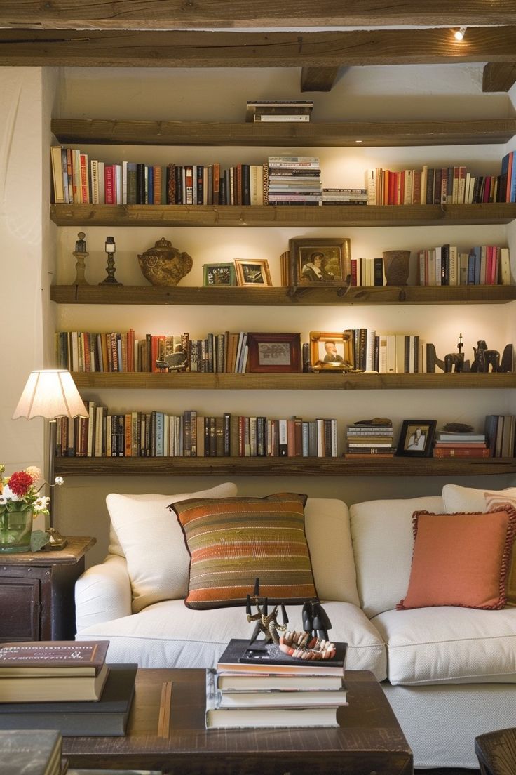 a living room filled with furniture and lots of books on the shelves in front of it