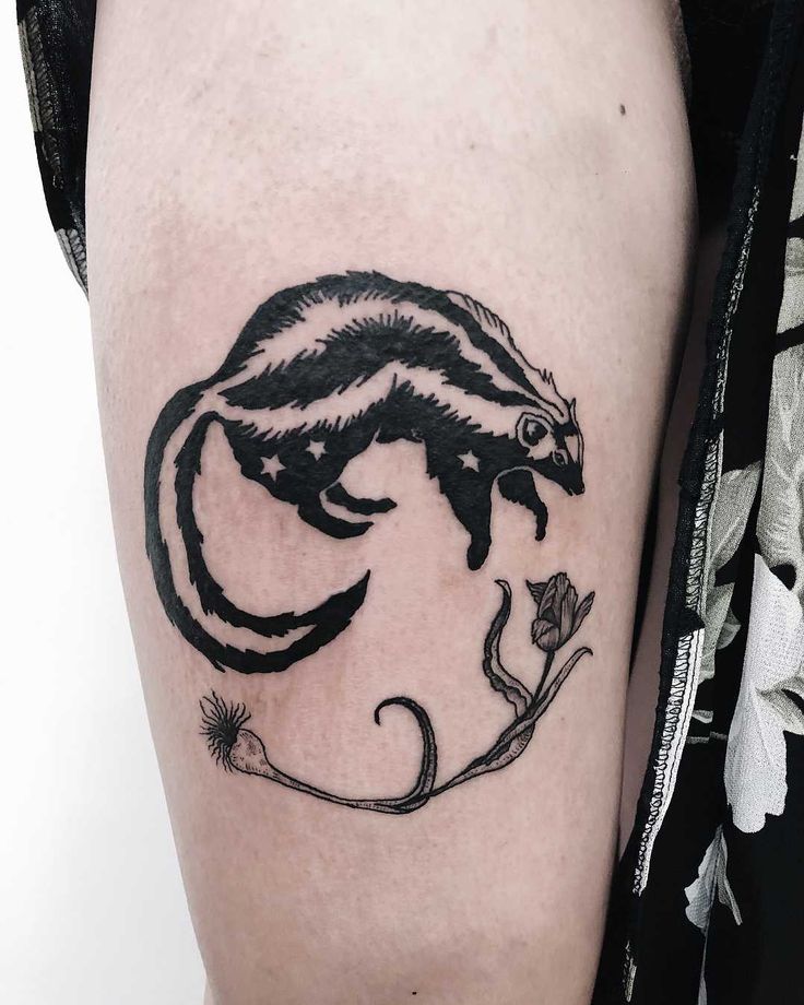 a small black and white animal tattoo on the right thigh