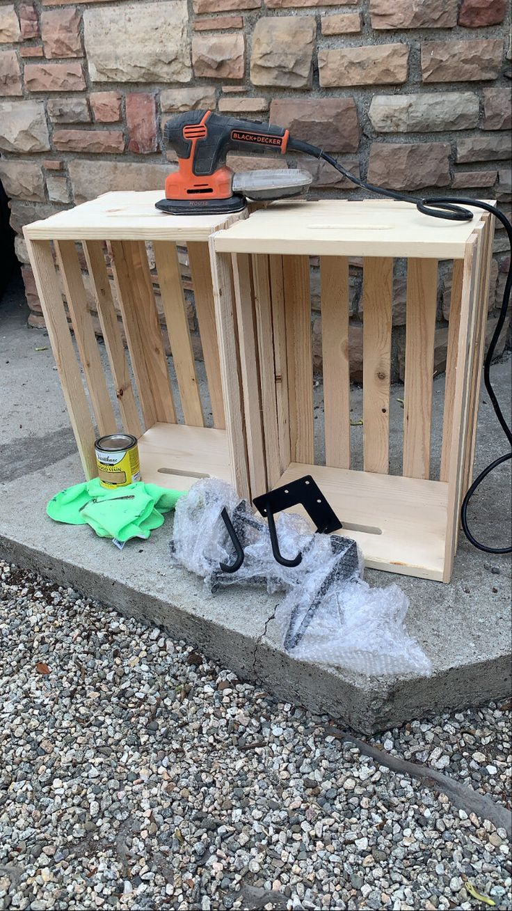 a wooden crate sitting on top of a sidewalk next to a wall with tools in it