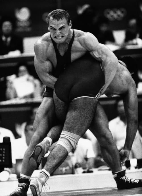 two men wrestling in an indoor wrestling match