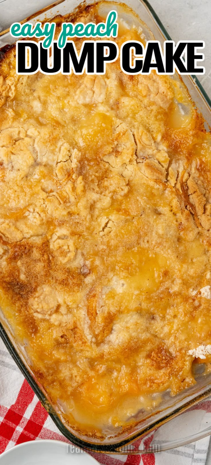 an easy peach dump cake recipe in a glass baking dish on a red and white checkered tablecloth