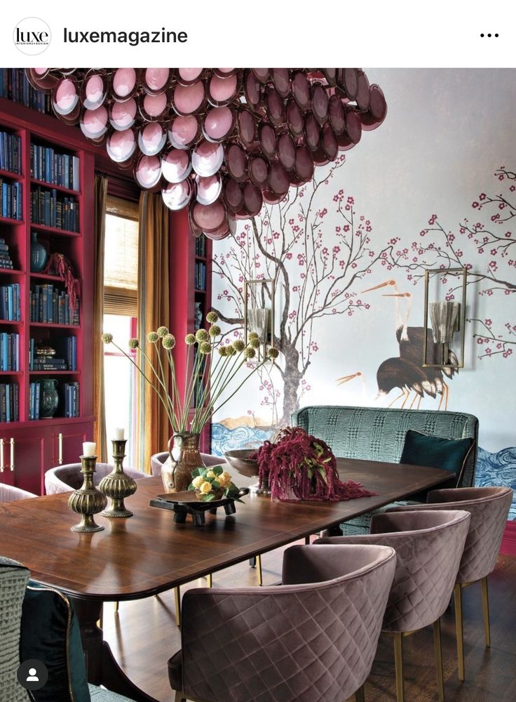 the dining room table is surrounded by chairs and bookshelves with pink flowers on them