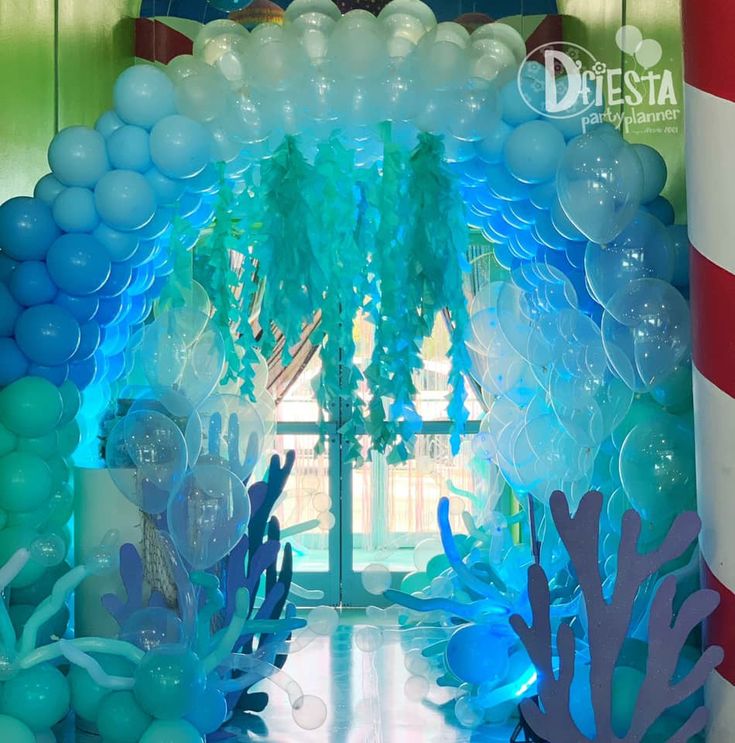 the balloon arch is decorated with blue, green and white underseam balloons for an under the sea party