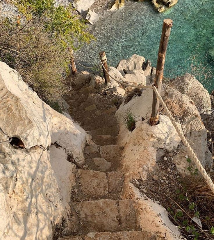 stairs lead down to the water from a rocky cliff