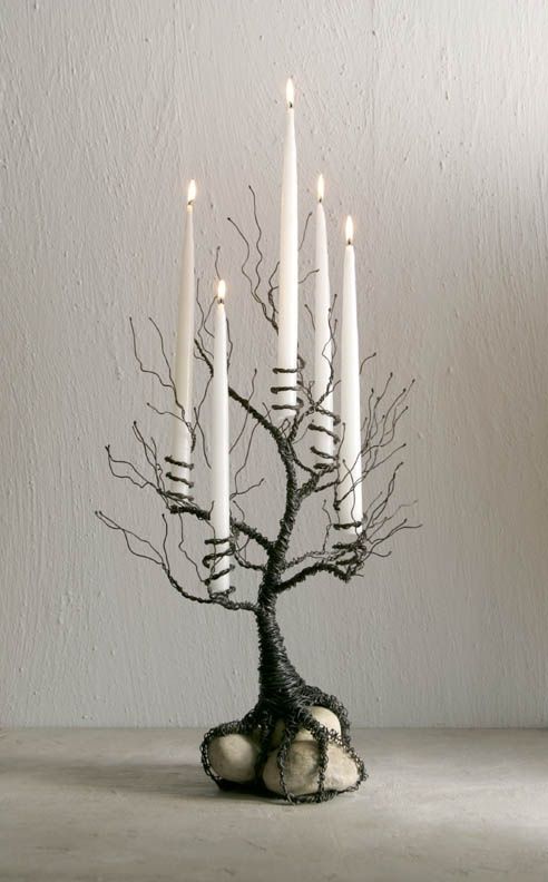 a small tree with white candles in it