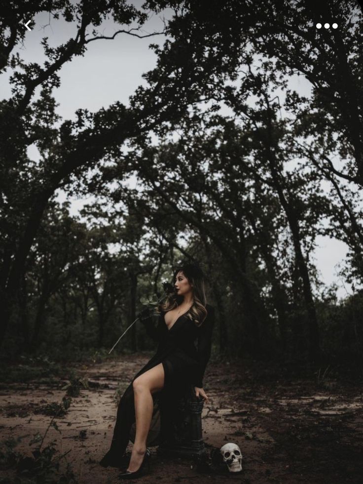 a woman sitting in the middle of a forest