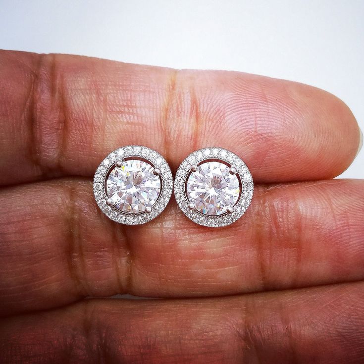 These Halo Diamond Stud Earrings are one of a kind. They look fabulous and beautiful when worn. This pair of Round cut or Round shape simulated diamonds is excellent cut, Bright White D Color, and VVS1 Purity. These Earrings feature screw backs for secure locking. Comes with a perfect Gift Box, Ideal for Gifting. A great Valentines gift for Valentine's day for your Valentine's love. Ultra-luxurious and sophisticated this dramatic diamonds Simulant Halo earrings studs are made of sterling silver Halo Diamond Earrings In Sterling Silver, Round Halo Diamond Earrings In Sterling Silver, Sterling Silver Round Halo Diamond Earrings, Round Sterling Silver Halo Earrings, Sterling Silver Round Halo Cluster Earrings, Sterling Silver Halo Round Earrings, Sterling Silver Cluster Earrings With Halo, Dazzling Round Cluster Earrings For Anniversary, Anniversary Halo Earrings