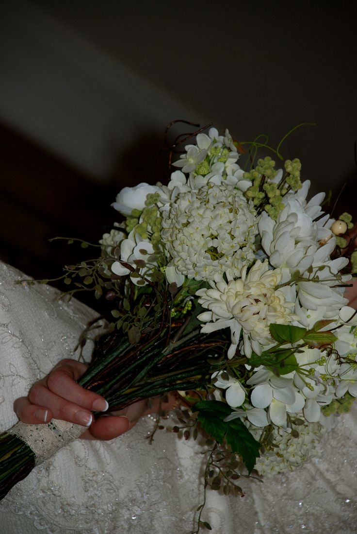 a bride holding a bouquet of white flowers