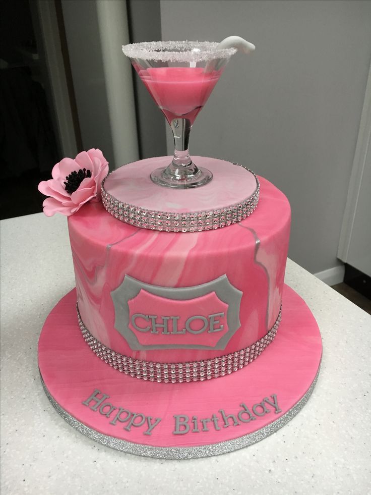 a pink birthday cake with a martini glass on top