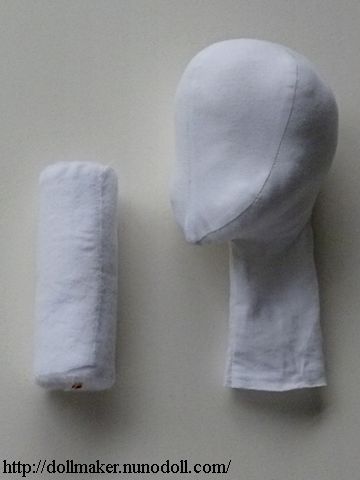 the head and arm of a doll are made out of white fabric, which is rolled up