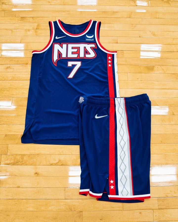 a jersey and shorts are on the floor in front of a basketball court with wooden floors