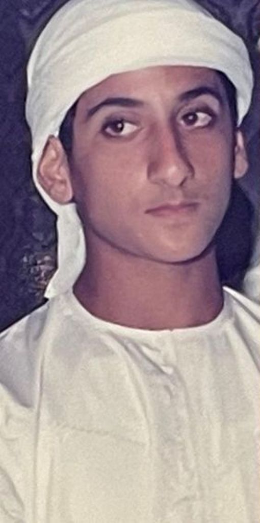 an old photo of a young man with a white headband and turban