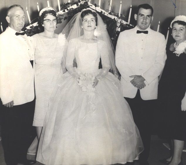 an old black and white photo of a bride and groom with two men in tuxedos