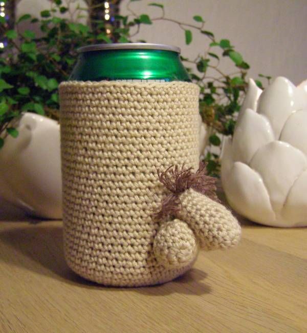 a crocheted coffee cup holder with a teddy bear on the bottom and a green lid